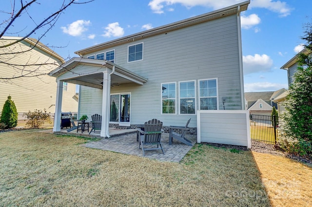 back of property with a lawn, ceiling fan, and a patio area