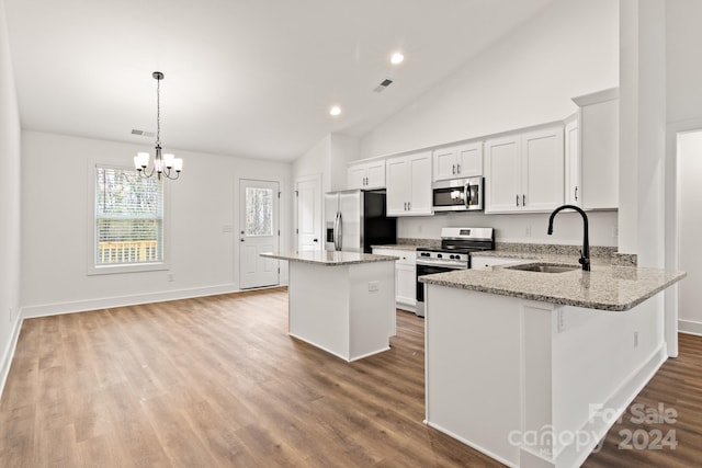 kitchen with appliances with stainless steel finishes, sink, decorative light fixtures, a notable chandelier, and white cabinetry