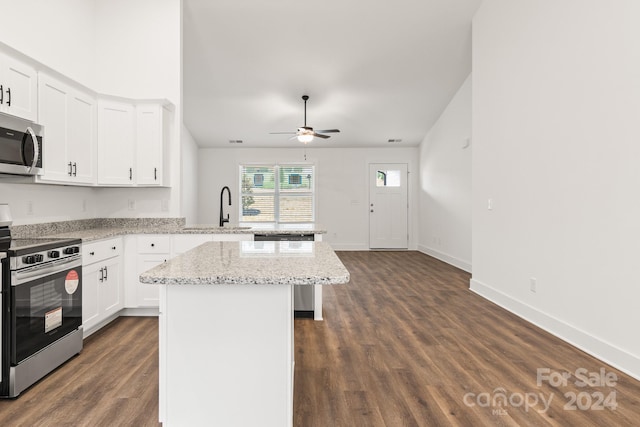 kitchen featuring light stone countertops, sink, a kitchen island, white cabinets, and appliances with stainless steel finishes