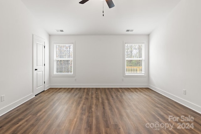 empty room with ceiling fan and dark hardwood / wood-style flooring