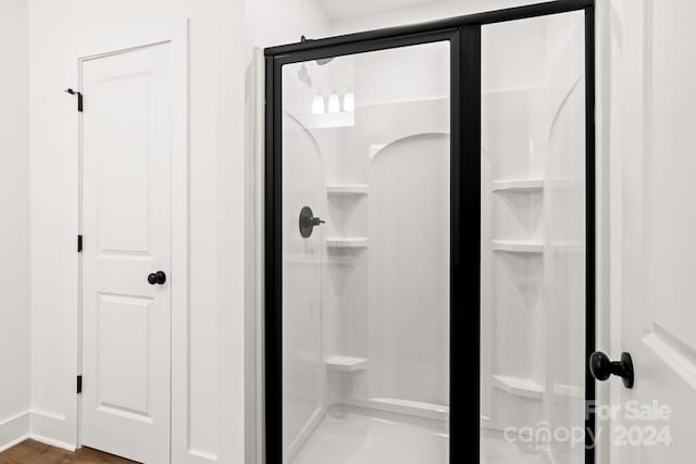 bathroom featuring a shower with door