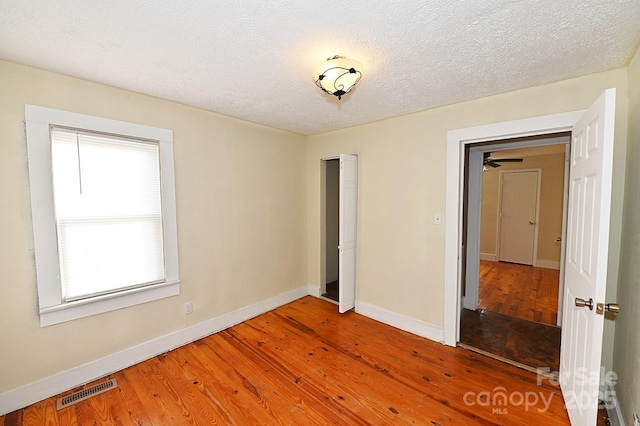 unfurnished bedroom with hardwood / wood-style floors and a textured ceiling