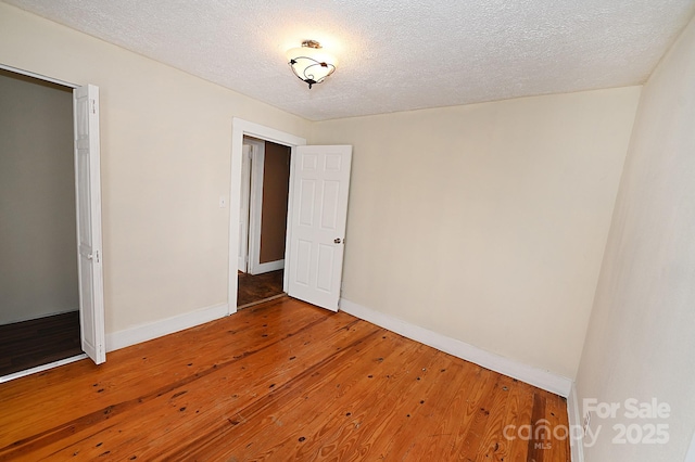 unfurnished bedroom featuring hardwood / wood-style floors and a textured ceiling