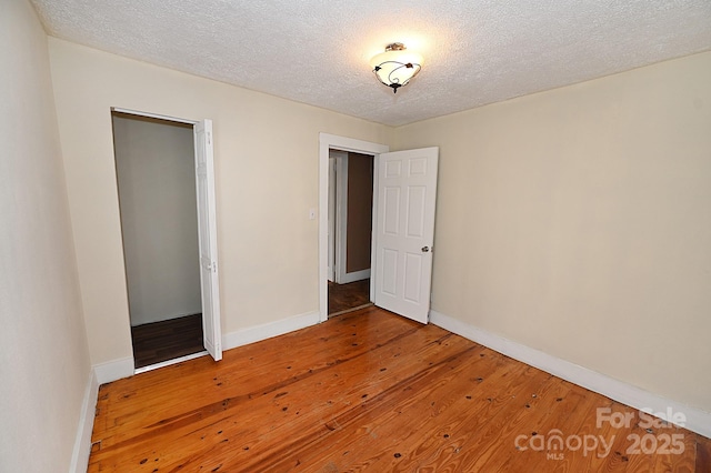 unfurnished bedroom with wood-type flooring and a textured ceiling