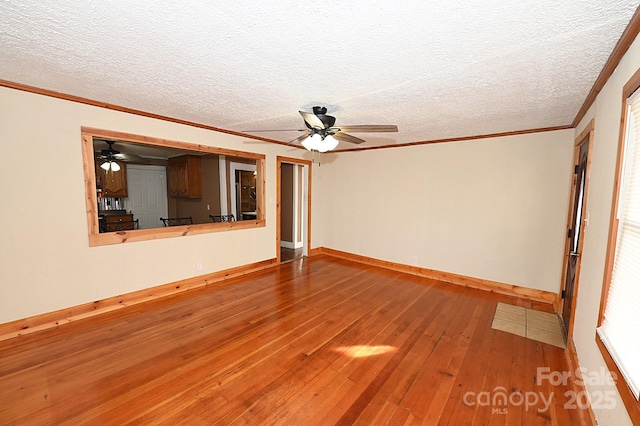 unfurnished living room featuring ceiling fan, wood-type flooring, a textured ceiling, and ornamental molding