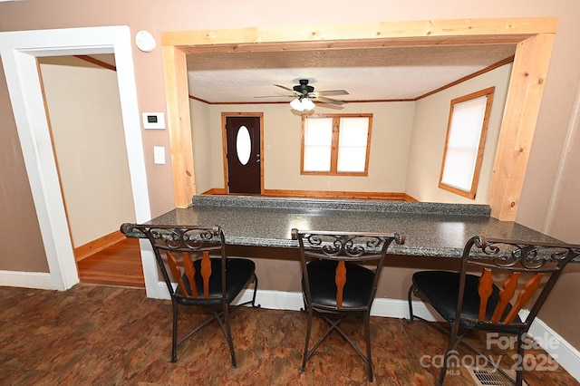 kitchen featuring built in desk, ceiling fan, and crown molding