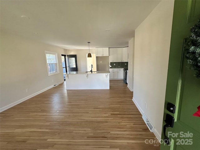 unfurnished living room featuring light wood-type flooring and sink