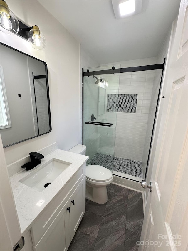 bathroom with vanity, an enclosed shower, and toilet