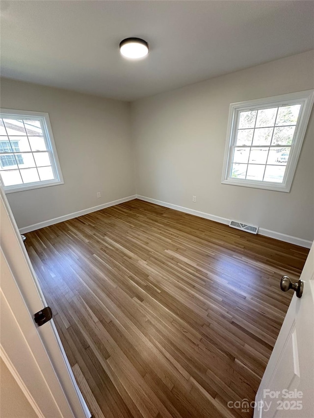 spare room with dark wood-type flooring