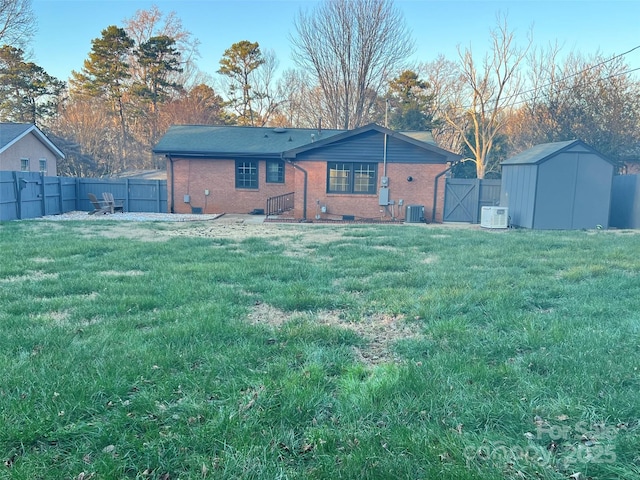 rear view of property with central air condition unit and a lawn