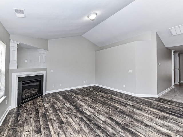 unfurnished living room with hardwood / wood-style floors and vaulted ceiling