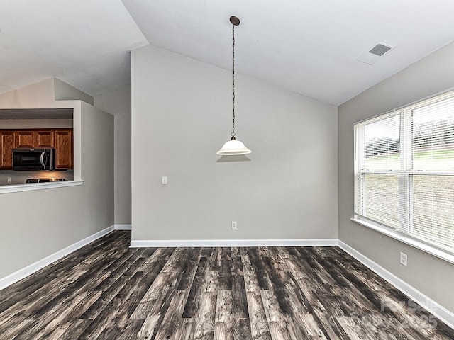 unfurnished dining area with dark wood-type flooring and lofted ceiling