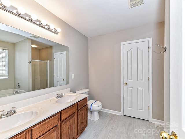 full bathroom featuring separate shower and tub, vanity, and toilet