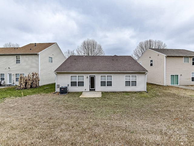 rear view of house with a yard, a patio, and central AC