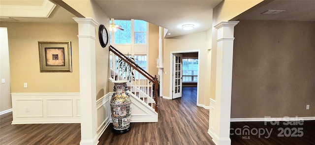 hallway with decorative columns, dark hardwood / wood-style flooring, and ornamental molding