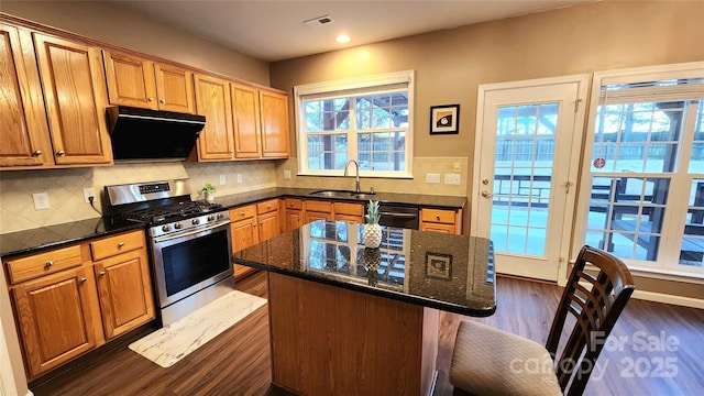 kitchen with gas stove, a center island, sink, black dishwasher, and dark stone counters