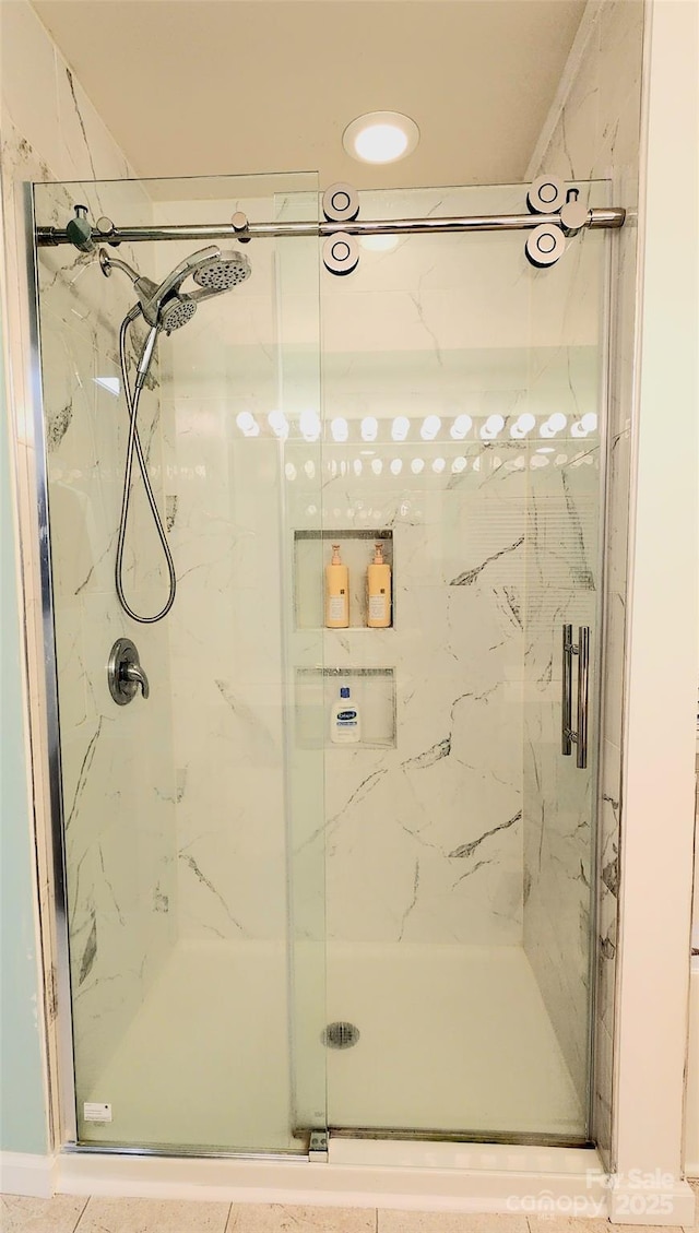 bathroom with a shower with door