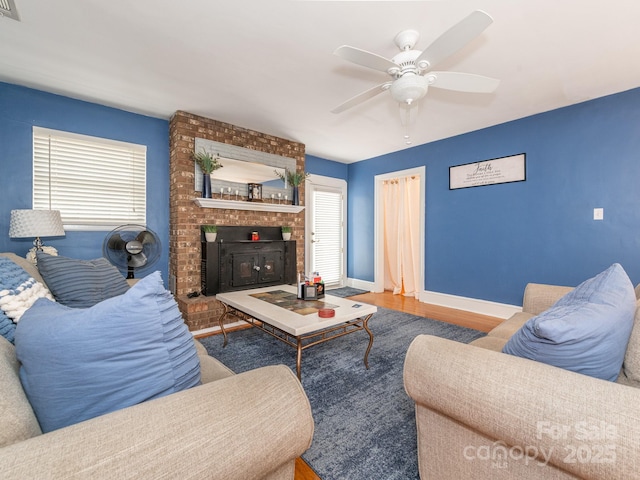 living room featuring a brick fireplace, ceiling fan, and hardwood / wood-style flooring