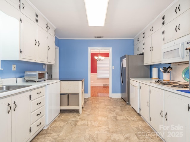 kitchen with white cabinetry, sink, an inviting chandelier, crown molding, and white appliances