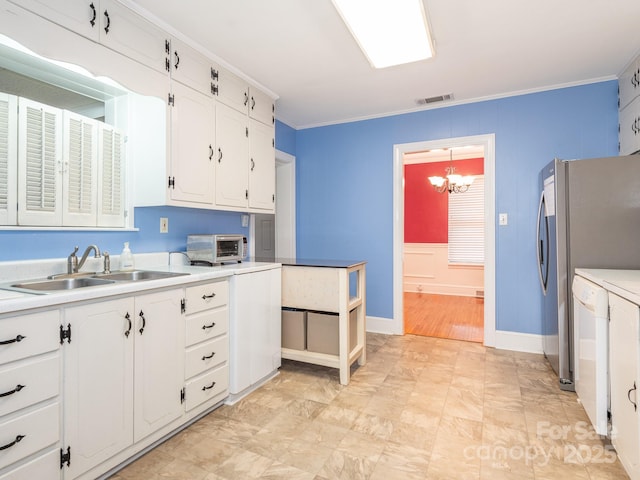 kitchen featuring sink, white cabinets, pendant lighting, and ornamental molding