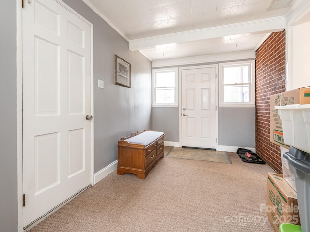 carpeted entrance foyer featuring ornamental molding and brick wall