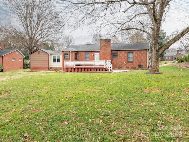 rear view of property featuring a lawn and a wooden deck