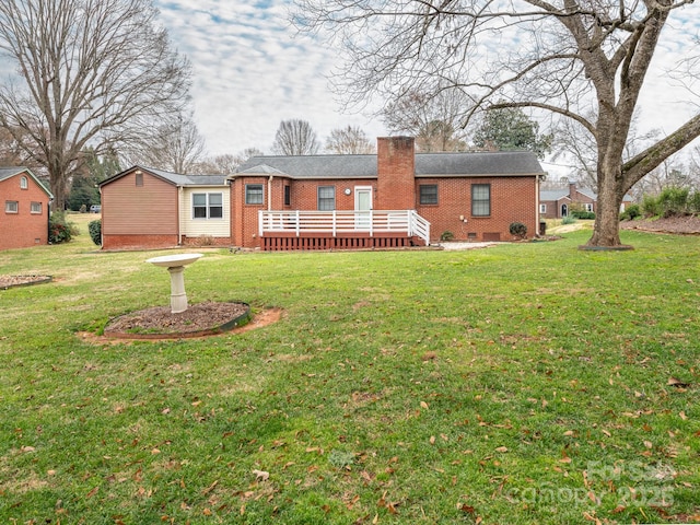 back of house featuring a lawn and a wooden deck