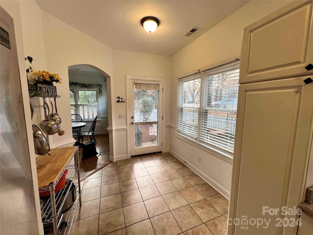 doorway to outside with light tile patterned flooring