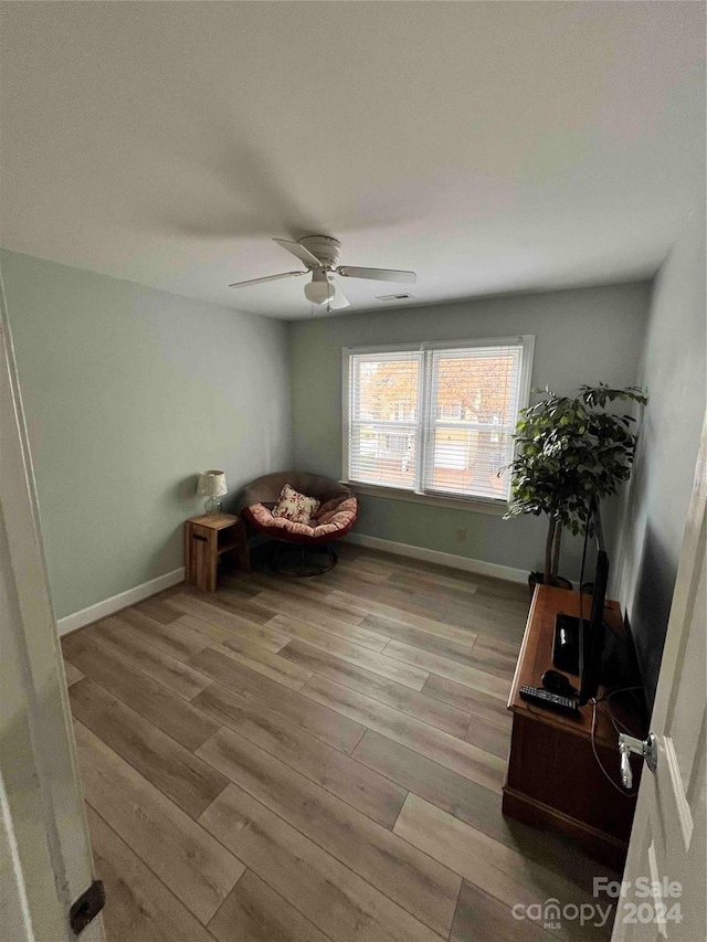 sitting room with ceiling fan and light hardwood / wood-style flooring