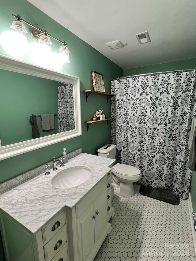 bathroom featuring tile patterned flooring, vanity, a shower with shower curtain, and toilet