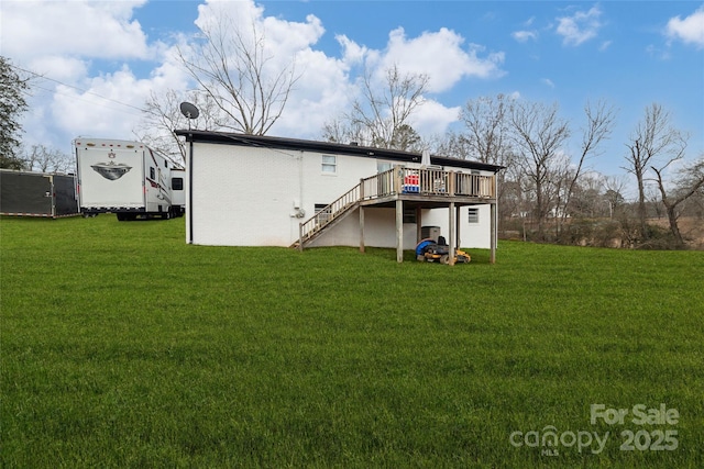 rear view of house with a wooden deck and a yard