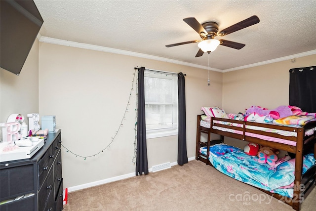 carpeted bedroom with a textured ceiling, ceiling fan, and ornamental molding