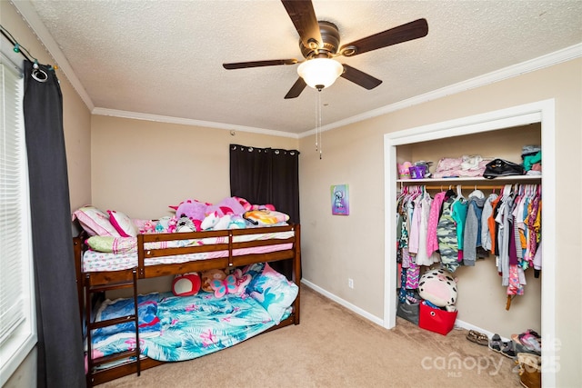 bedroom featuring ceiling fan, a closet, light carpet, and ornamental molding