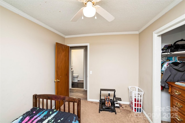 bedroom featuring ceiling fan, light colored carpet, a textured ceiling, and ornamental molding