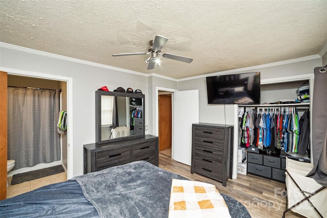 bedroom featuring a textured ceiling, a closet, ceiling fan, and ornamental molding