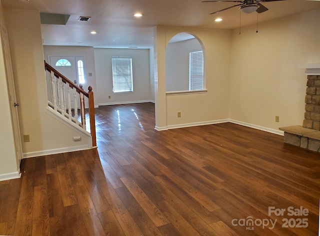 unfurnished living room featuring ceiling fan, dark hardwood / wood-style flooring, and a fireplace