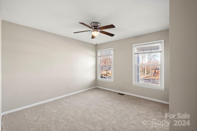 carpeted empty room featuring ceiling fan