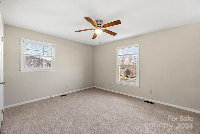 carpeted spare room featuring ceiling fan