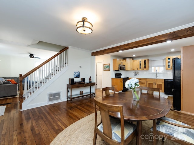 dining area featuring crown molding, sink, dark wood-type flooring, and ceiling fan