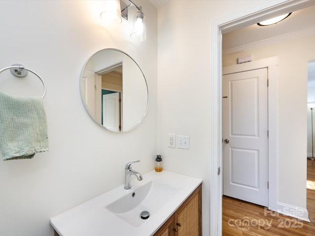 bathroom featuring vanity, crown molding, and hardwood / wood-style flooring