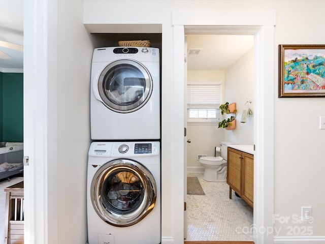 washroom featuring stacked washer / drying machine