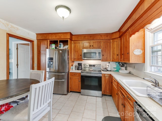 kitchen featuring light tile patterned floors, stainless steel appliances, and sink