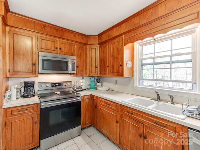 kitchen featuring light tile patterned floors, stainless steel appliances, and sink