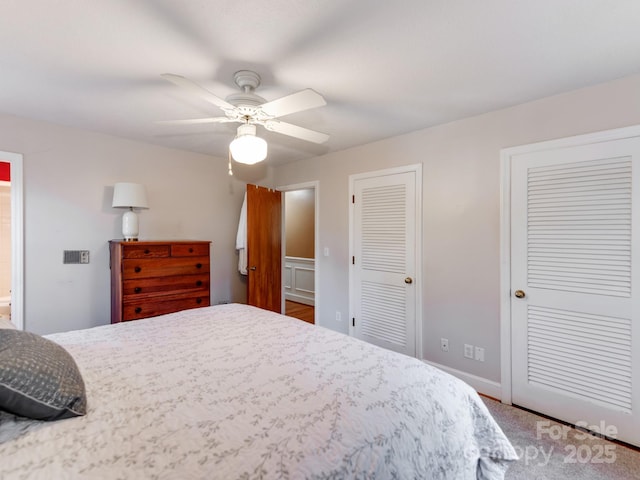 bedroom featuring ceiling fan and two closets