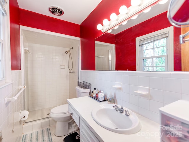 bathroom featuring tile patterned flooring, toilet, tile walls, tasteful backsplash, and a tile shower