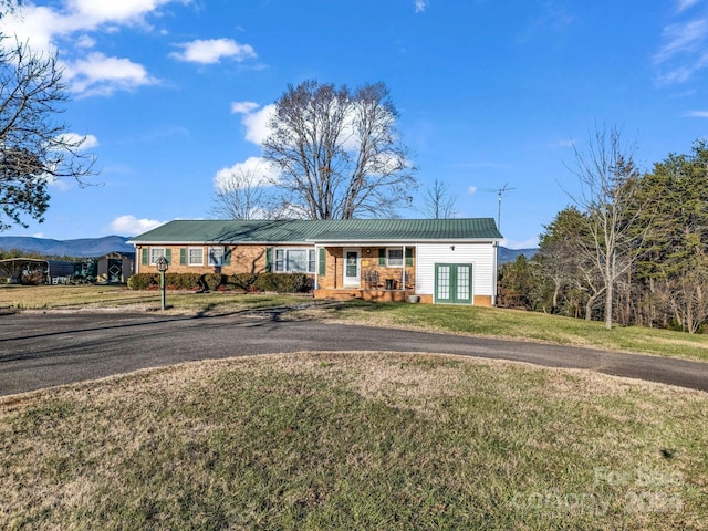 ranch-style home featuring a mountain view, french doors, and a front yard