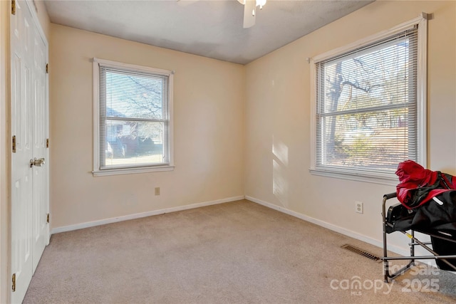 interior space featuring ceiling fan and light carpet