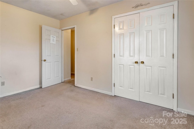 unfurnished bedroom featuring light colored carpet, a closet, and ceiling fan