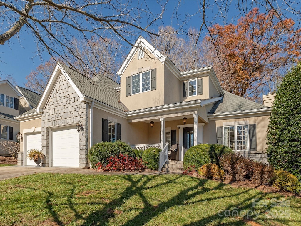 view of front of house with a front yard, a porch, and a garage