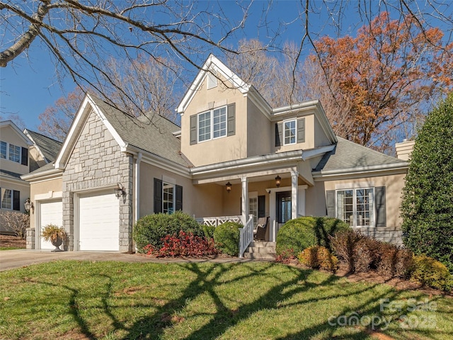 view of front of house with a front yard, a porch, and a garage